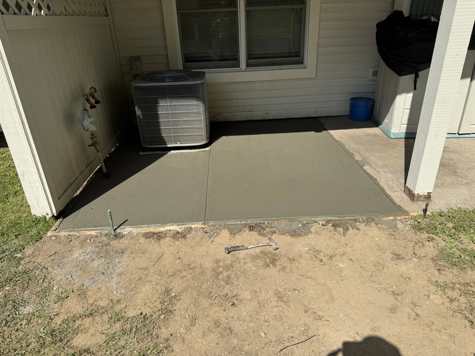 Newly finished concrete pad beside a property